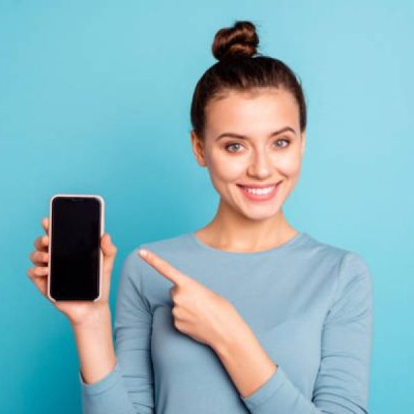 Close-up portrait of her she nice-looking attractive sweet lovely cheerful teenage girl holding in hand new cool buying purchase ad advert isolated over bright vivid shine turquoise background.